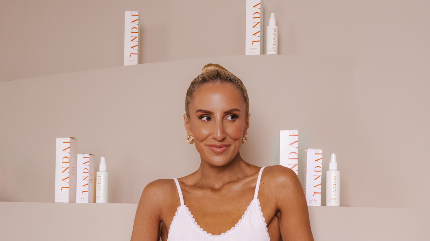 Tandae Founder, Georgia Davies poses with Tandae products behind her.